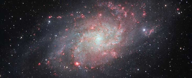 El telescopio de sondeo VST (VLT Survey Telescope), instalado en el Observatorio Paranal de ESO, en Chile, ha captado una imagen de la galaxia Messier 33, también conocida como la Galaxia del Triángulo.  Esta espiral cercana, la segunda gran galaxia más cercana a la nuestra, la Vía Láctea, está llena de brillantes cúmulos de estrellas y de nubes de gas y polvo. Esta fotografía es una de las imágenes de amplio campo con más detalles jamás tomada de este objeto y muestra, con especial claridad, las numerosas nubes rojizas y brillantes de gas en los brazos espirales.