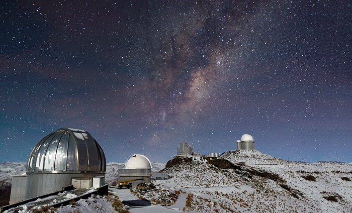 Vintergatan lyser över ett snötäckt La Silla