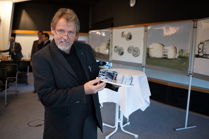 Architect of the ESO Supernova Planetarium & Visitor Centre showing a model of the planned building
