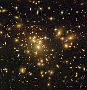A galáxia poeirenta longínqua A1689-zD1 por trás do enxame de galáxias Abell 1689