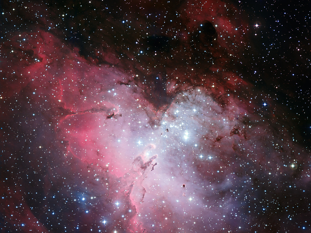Nebulosa da Águia, onde se observam tanto extensas regiões de emissão de luz vermelha, emitida pelos átomos de hidrogénio, como partes escuras, de gás e poeira, que são berços de estrelas.